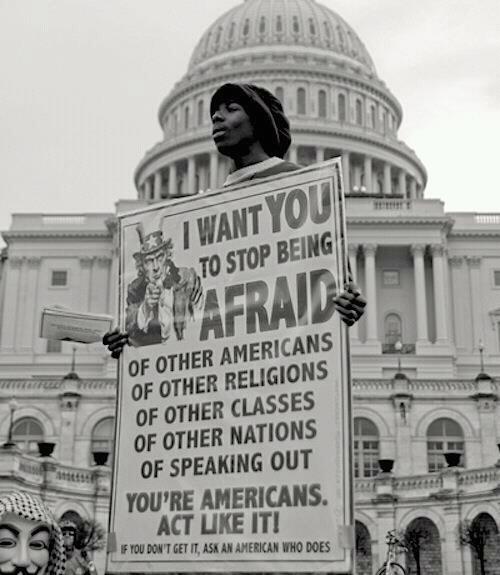 "Washington DC: A black man holds a poster with Uncle Sam on it that says I want you to stop being afraid of other americans, of other religions, of other classes, of other nations, of speaking out. You're Americans. Act like it! If you don't get it, ask an American that does. The bottom left corner also has the head of a person wearing a Guy Fawkes mask barely visible. Source unknown."