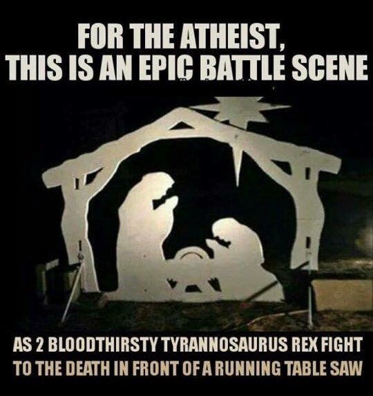 “A wooden silhouette of the Nativity, captioned for the atheist this is an epic battle scene as 2 bloodthirsty tyrannosaurus rex fight to the death in front of a running table saw.”